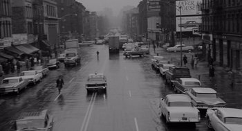 Movie still from “The Pawnbroker” (1964), directed by Sidney Lumet – A black - and - white photo of a city street with cars driving down it; Extreme Wide shot, High angle