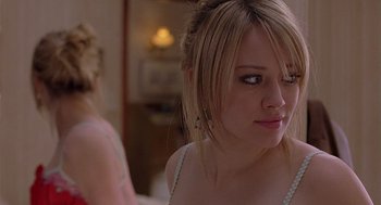 Movie still from “The Perfect Man” (2005), directed by Mark Rosman – A young woman looking at the camera in front of a mirror; Close Up shot, Over the shoulder angle