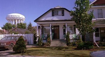 Movie still from “The Perfect Man” (2005), directed by Mark Rosman – A white house sitting on top of a lush green field; Extreme Wide shot, Low angle