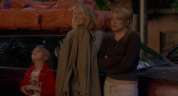 Movie still from “The Perfect Man” (2005), directed by Mark Rosman – Two women standing next to each other in front of a car; Medium shot, Low angle