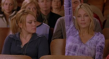 Movie still from “The Perfect Man” (2005), directed by Mark Rosman – A woman raises her hand in front of a crowd; Medium shot, High angle
