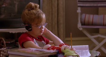 Movie still from “The Perfect Man” (2005), directed by Mark Rosman – A young girl wearing headphones while sitting at a desk; Medium shot, High angle