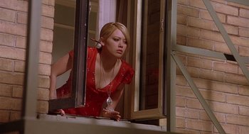 Movie still from “The Perfect Man” (2005), directed by Mark Rosman – A woman in a red dress looking out of a window; Medium shot, High angle