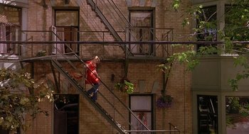 Movie still from “The Perfect Man” (2005), directed by Mark Rosman – A man riding a skateboard down the side of a fire escape; Extreme Wide shot, Overhead angle