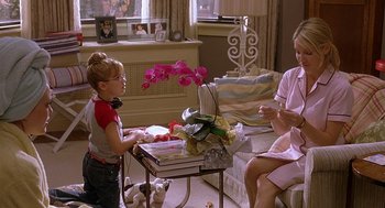 Movie still from “The Perfect Man” (2005), directed by Mark Rosman – A little girl sitting at a coffee table with her mother and grandmother; Medium shot, Over the shoulder angle