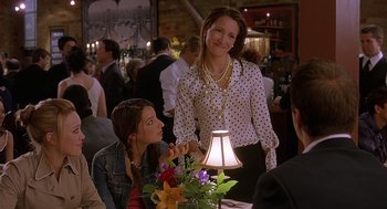 Movie still from “The Perfect Man” (2005), directed by Mark Rosman – A woman standing next to a woman sitting at a table; Medium shot, Over the shoulder angle
