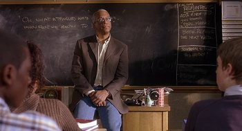 Movie still from “The Perfect Man” (2005), directed by Mark Rosman – A man sitting in front of a chalkboard in a classroom; Medium shot, Over the shoulder angle