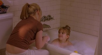 Movie still from “The Perfect Man” (2005), directed by Mark Rosman – A young girl sitting in a bath tub while a woman washes her hands; Medium shot, High angle