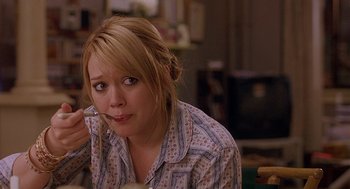 Movie still from “The Perfect Man” (2005), directed by Mark Rosman – A woman sitting in front of a table with a phone; Medium shot, High angle