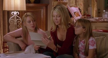 Movie still from “The Perfect Man” (2005), directed by Mark Rosman – Two women and a little girl looking at a piece of paper; Medium shot, Over the shoulder angle
