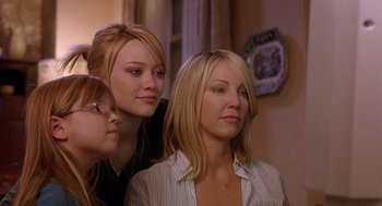 Movie still from “The Perfect Man” (2005), directed by Mark Rosman – Three young women looking at the camera in a living room; Close Up shot, Over the shoulder angle