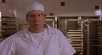 Movie still from “The Perfect Man” (2005), directed by Mark Rosman – A man wearing a white hat in front of a bunch of pans in a kitchen; Close Up shot, Over the shoulder angle