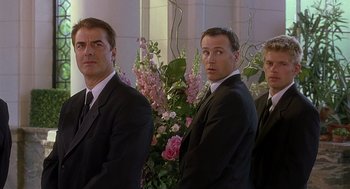 Movie still from “The Perfect Man” (2005), directed by Mark Rosman – A group of men standing next to each other in front of flowers; Medium shot, Low angle