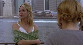 Movie still from “The Perfect Man” (2005), directed by Mark Rosman – Two women sitting on a pier near a body of water; Medium shot, Over the shoulder angle