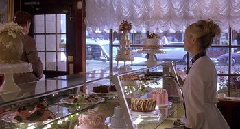 Movie still from “The Perfect Man” (2005), directed by Mark Rosman – A display case filled with lots of cakes and deserts; Wide shot, Over the shoulder angle