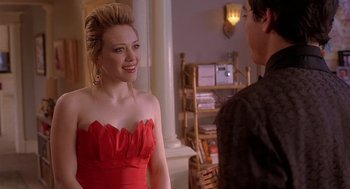 Movie still from “The Perfect Man” (2005), directed by Mark Rosman – A woman in a red dress talking to a man in front of a bookshelf; Medium shot, Over the shoulder angle