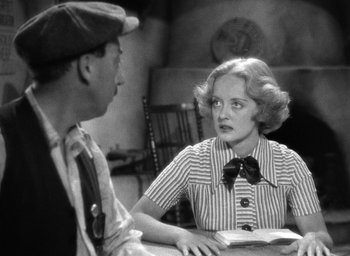 Movie still from “The Petrified Forest” (1936), directed by Archie Mayo – An old photo of a man and a woman sitting at a table; Medium shot, Over the shoulder angle