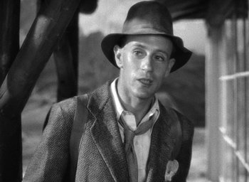 Movie still from “The Petrified Forest” (1936), directed by Archie Mayo – A man wearing a suit and a hat; Close Up shot, Low angle