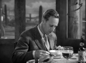 Movie still from “The Petrified Forest” (1936), directed by Archie Mayo – A man sitting at a table with a bowl of soup; Medium shot, High angle