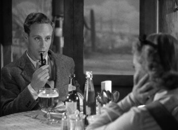Movie still from “The Petrified Forest” (1936), directed by Archie Mayo – A man sitting at a table with a woman; Medium shot, Over the shoulder angle