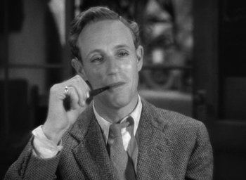 Movie still from “The Petrified Forest” (1936), directed by Archie Mayo – A man in a suit and tie holding a pipe in his mouth; Close Up shot, High angle