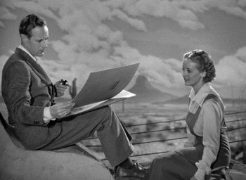 Movie still from “The Petrified Forest” (1936), directed by Archie Mayo – A man and a woman sitting on top of a hill; Medium shot, Low angle