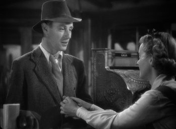 Movie still from “The Petrified Forest” (1936), directed by Archie Mayo – A man in a suit and a woman in a hat; Medium shot, Low angle