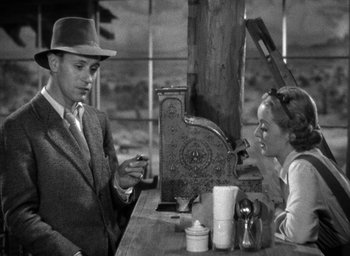 Movie still from “The Petrified Forest” (1936), directed by Archie Mayo – A man and a woman are sitting at a table; Medium shot, High angle