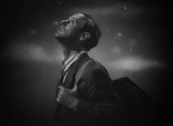 Movie still from “The Petrified Forest” (1936), directed by Archie Mayo – A black and white photo of a man in a suit and tie; Medium shot, Low angle