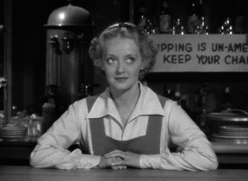 Movie still from “The Petrified Forest” (1936), directed by Archie Mayo – An older woman sitting at a counter in front of a sign; Close Up shot, Low angle
