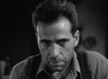 Movie still from “The Petrified Forest” (1936), directed by Archie Mayo – Black and white photograph of a man looking at the camera; Close Up shot, Low angle