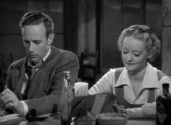 Movie still from “The Petrified Forest” (1936), directed by Archie Mayo – A man and a woman sitting at a dinner table; Medium shot, High angle