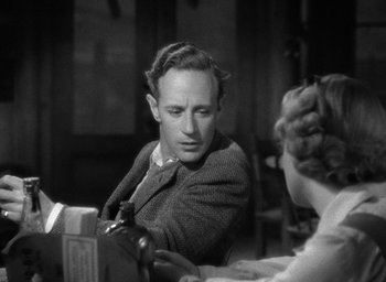 Movie still from “The Petrified Forest” (1936), directed by Archie Mayo – A man sitting at a table with a woman in front of him; Close Up shot, Over the shoulder angle