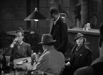 Movie still from “The Petrified Forest” (1936), directed by Archie Mayo – A black and white photo of people sitting at a table; Medium shot, High angle