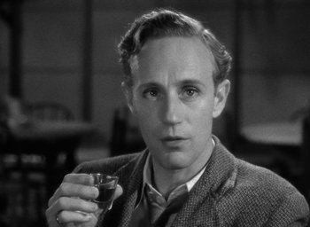 Movie still from “The Petrified Forest” (1936), directed by Archie Mayo – A man holding a glass in his right hand; Close Up shot, High angle