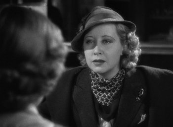 Movie still from “The Petrified Forest” (1936), directed by Archie Mayo – An old photo of a woman in a suit and hat; Close Up shot, Over the shoulder angle