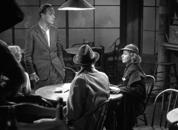 Movie still from “The Petrified Forest” (1936), directed by Archie Mayo – A group of people sitting around a table; Wide shot, High angle