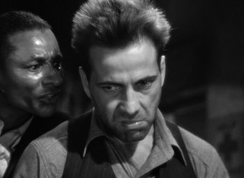 Movie still from “The Petrified Forest” (1936), directed by Archie Mayo – A black and white photo of a man and a woman; Close Up shot, Low angle