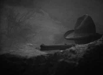Movie still from “The Petrified Forest” (1936), directed by Archie Mayo – A black and white photo of a hat and a gun; Extreme Close Up shot, High angle