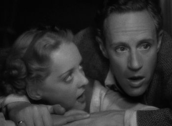 Movie still from “The Petrified Forest” (1936), directed by Archie Mayo – A man and a woman looking at the camera; Close Up shot, High angle