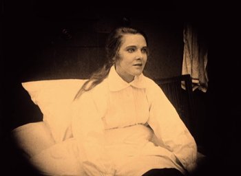 Movie still from “The Phantom Carriage” (1921), directed by Victor Sjöström – An old photo of a woman sitting on a bed; Medium shot, High angle