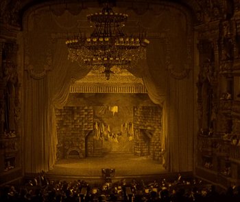 Movie still from “The Phantom of the Opera” (1925), directed by Lon Chaney – A stage with a chandelier and a crowd of people in it; Extreme Wide shot, High angle