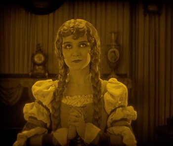 Movie still from “The Phantom of the Opera” (1925), directed by Lon Chaney – A woman in a yellow dress with braids and a long veil; Medium shot, High angle