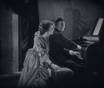 Movie still from “The Phantom of the Opera” (1925), directed by Lon Chaney – A man and a woman are playing the piano; Medium shot, High angle