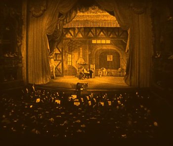 Movie still from “The Phantom of the Opera” (1925), directed by Lon Chaney – A large crowd of people are watching a stage show; Extreme Wide shot, High angle