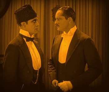 Movie still from “The Phantom of the Opera” (1925), directed by Lon Chaney – A couple of men standing next to each other; Medium shot, High angle