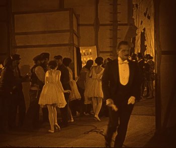 Movie still from “The Phantom of the Opera” (1925), directed by Lon Chaney – A man in a tuxedo walking down a hallway; Wide shot, High angle