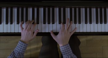 Movie still from “The Piano Teacher” (2001), directed by Michael Haneke – Two hands are playing the piano on the piano; Extreme Close Up shot, Overhead angle