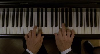 Movie still from “The Piano Teacher” (2001), directed by Michael Haneke – A person playing a piano with their hands on the keys; Extreme Close Up shot, Overhead angle