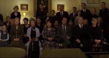 Movie still from “The Piano Teacher” (2001), directed by Michael Haneke – A group of people sitting in front of a painting; Wide shot, High angle